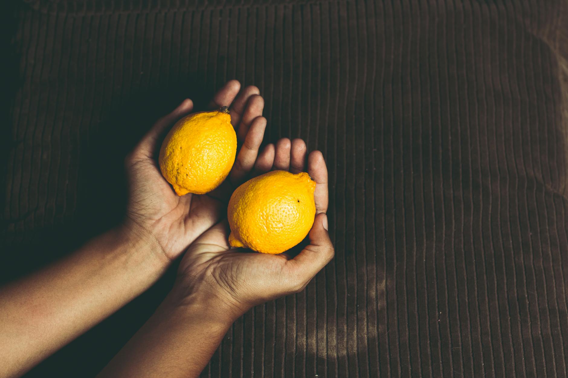 Bright yellow lemons on a pastel green background, symbolizing fresh pleasure and cycle-based sensation changes
