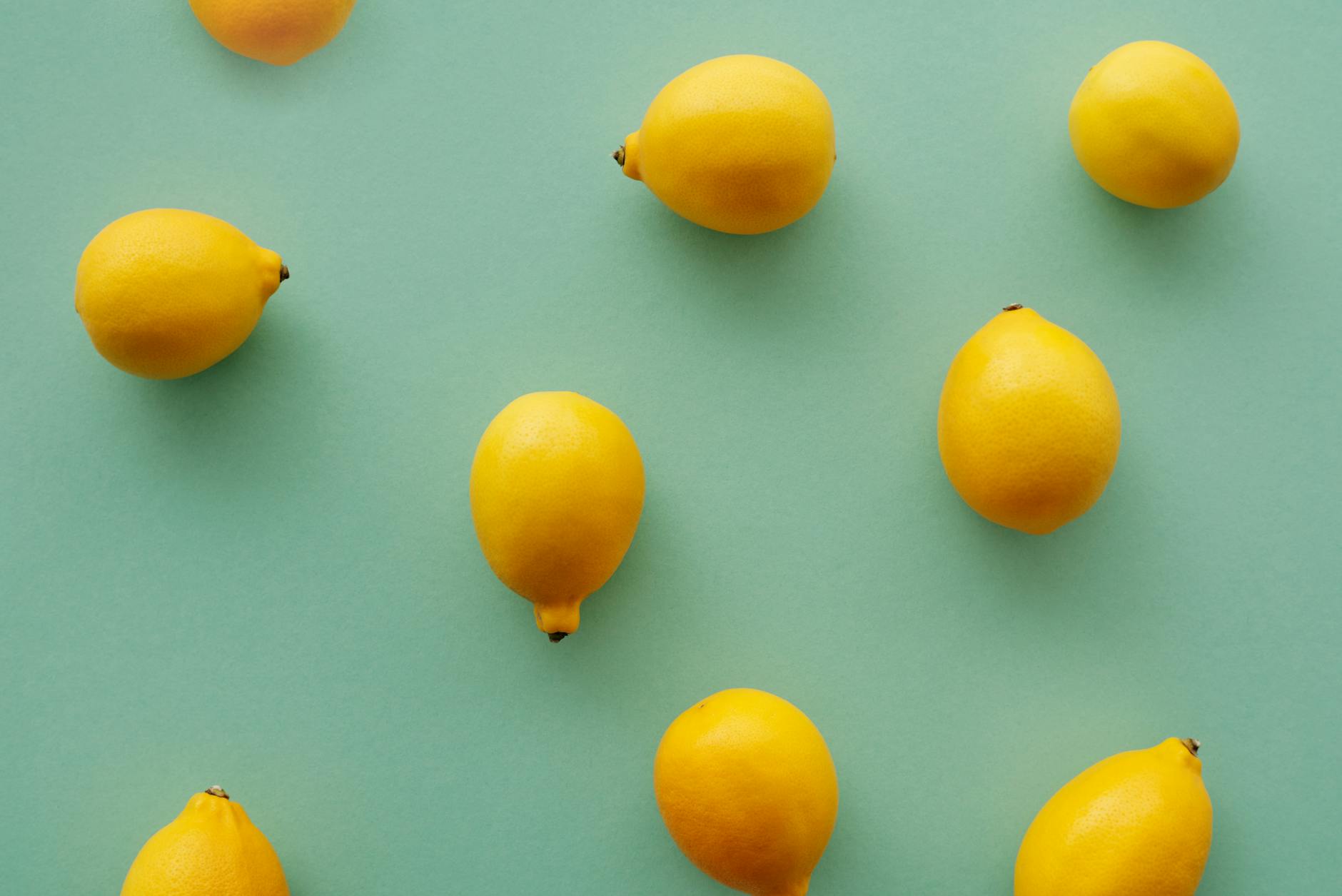 Yellow lemon vibrator surrounded by fresh fruit on a warm yellow background, symbolizing renewed pleasure