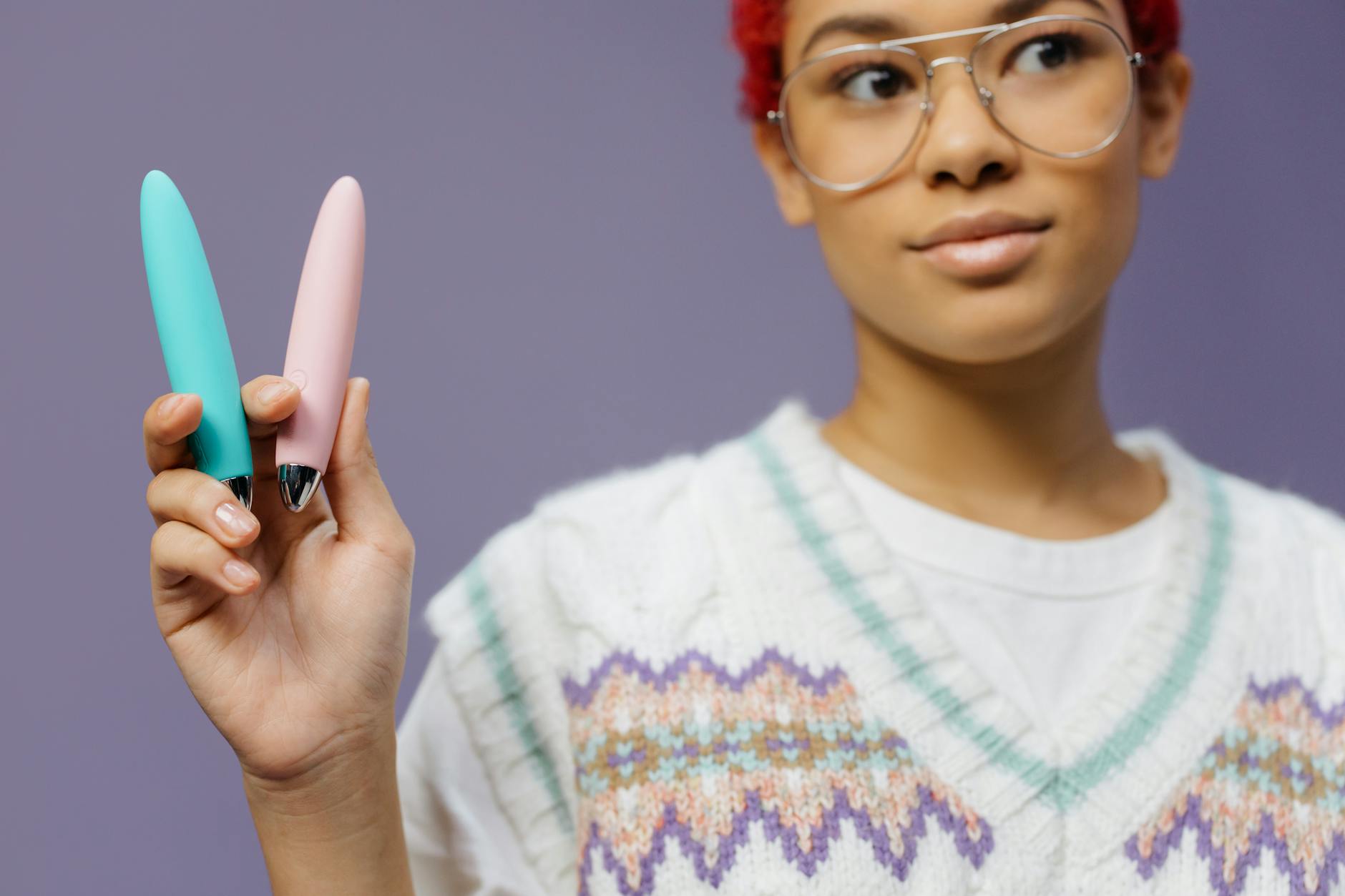 Femme tenant un vibromasseur citron coloré devant un fond mauve
